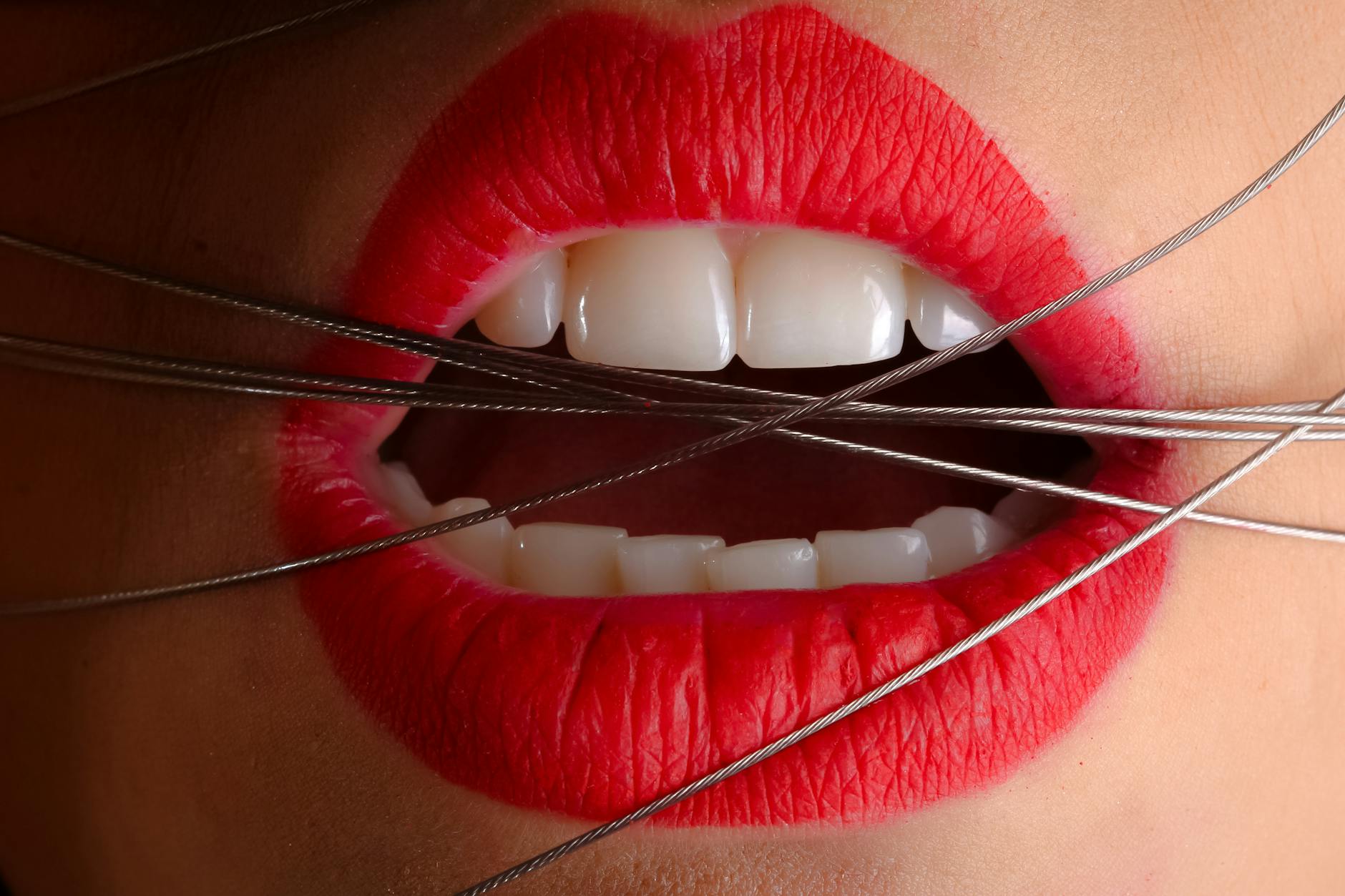 closeup photo of a woman with gray cables on his mouth