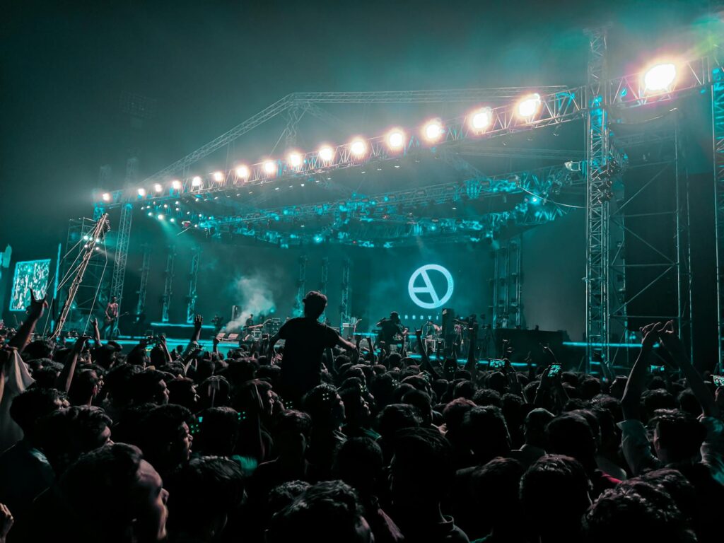 group of unrecognizable fans cheering at rock concert