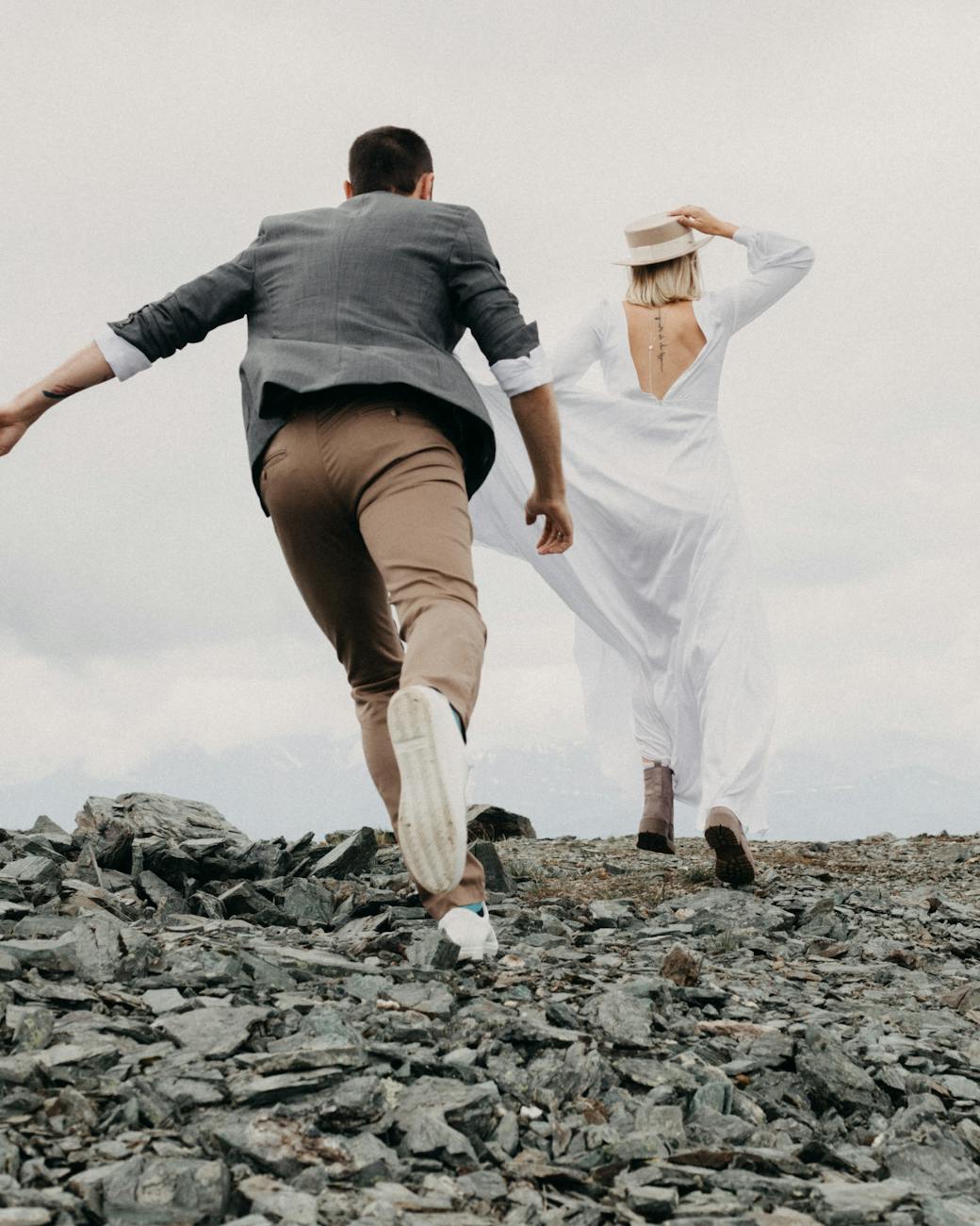 anonymous groom catching up bride on rocky land