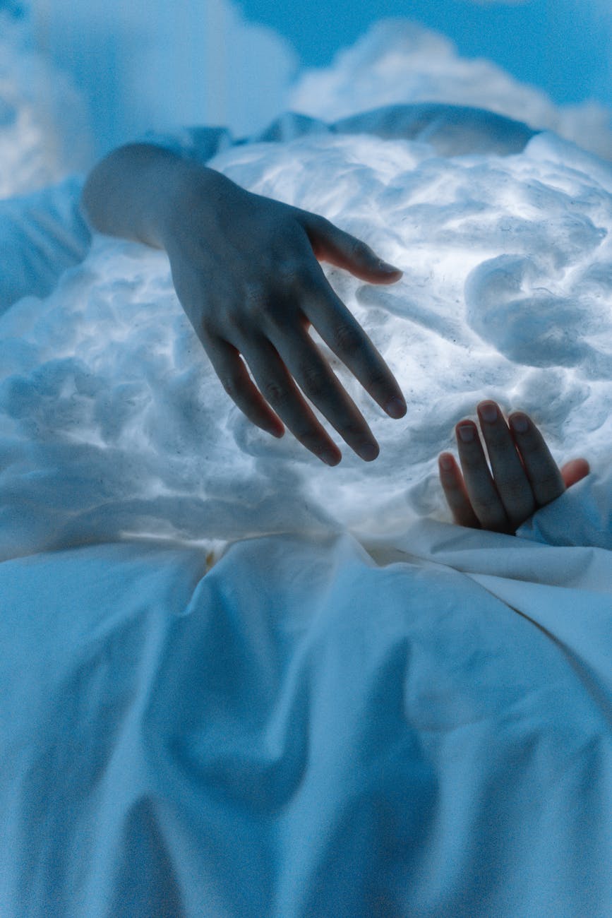 person embracing a white cloud in bed