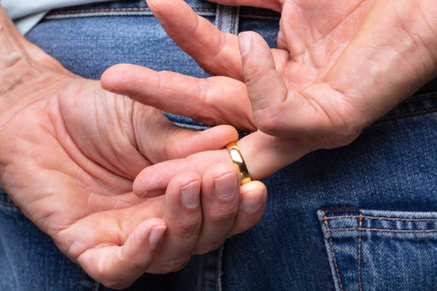 Close Da Mão De Um Homem tirando do dedo aliança De Ouro