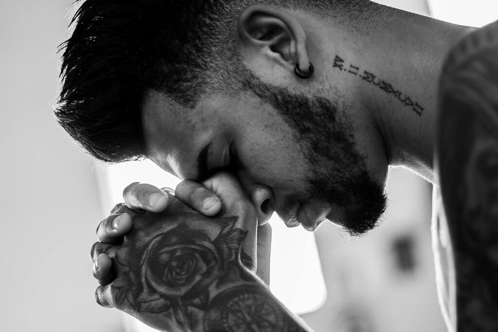 man tattooed praying