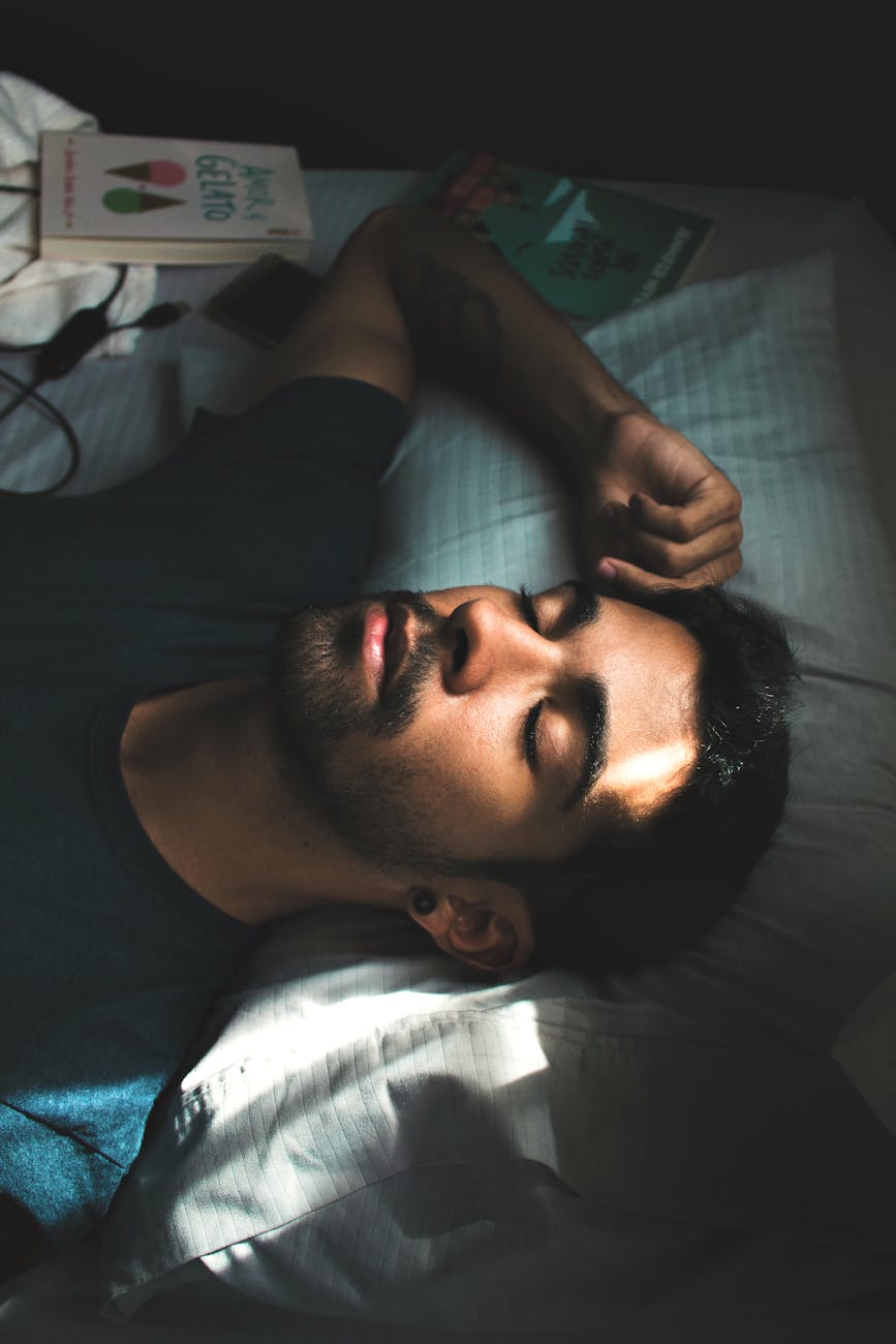 man in crew neck t shirt lying on bed