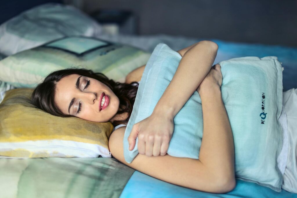 photo of a woman hugging a blue pillow