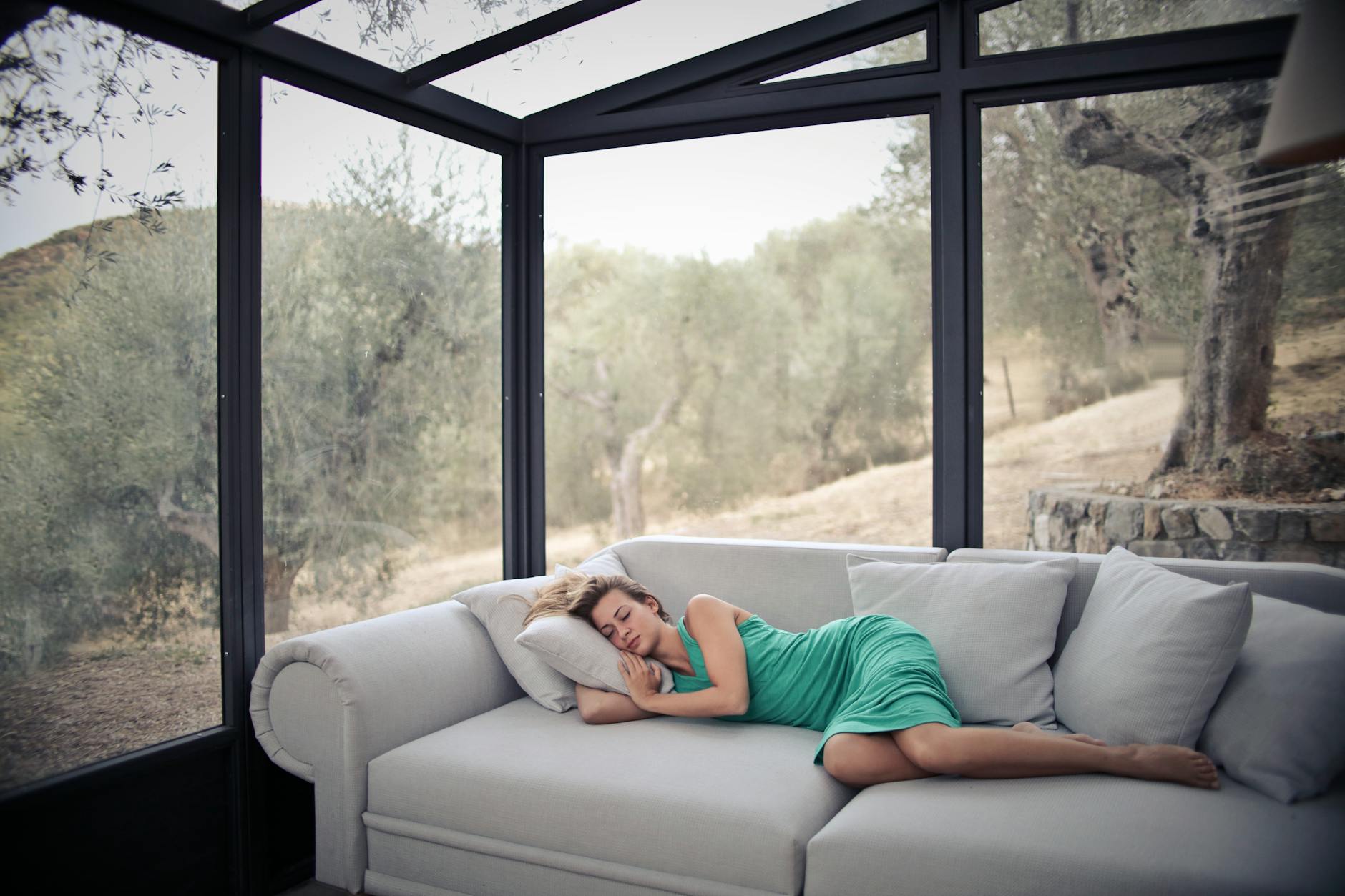 woman sleeping on sofa with throw pillows