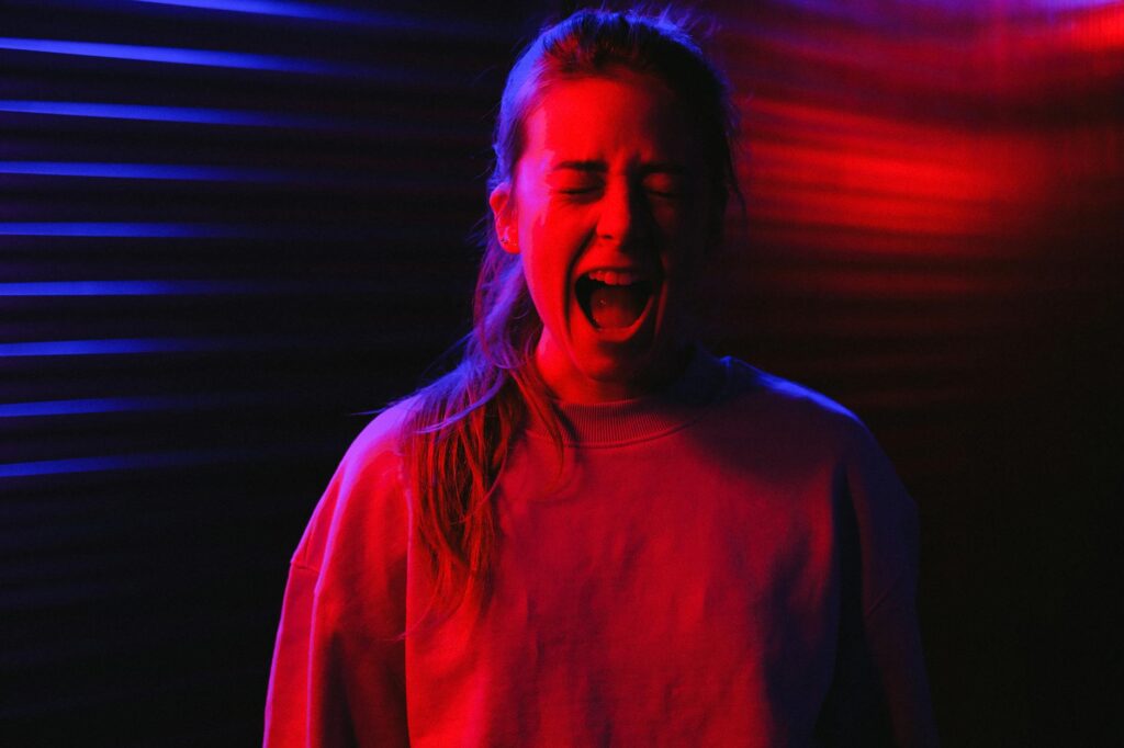 frightened female ccreaming on a dark room