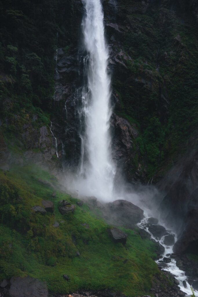 big waterfall in mountain valley coming from high rocky wall